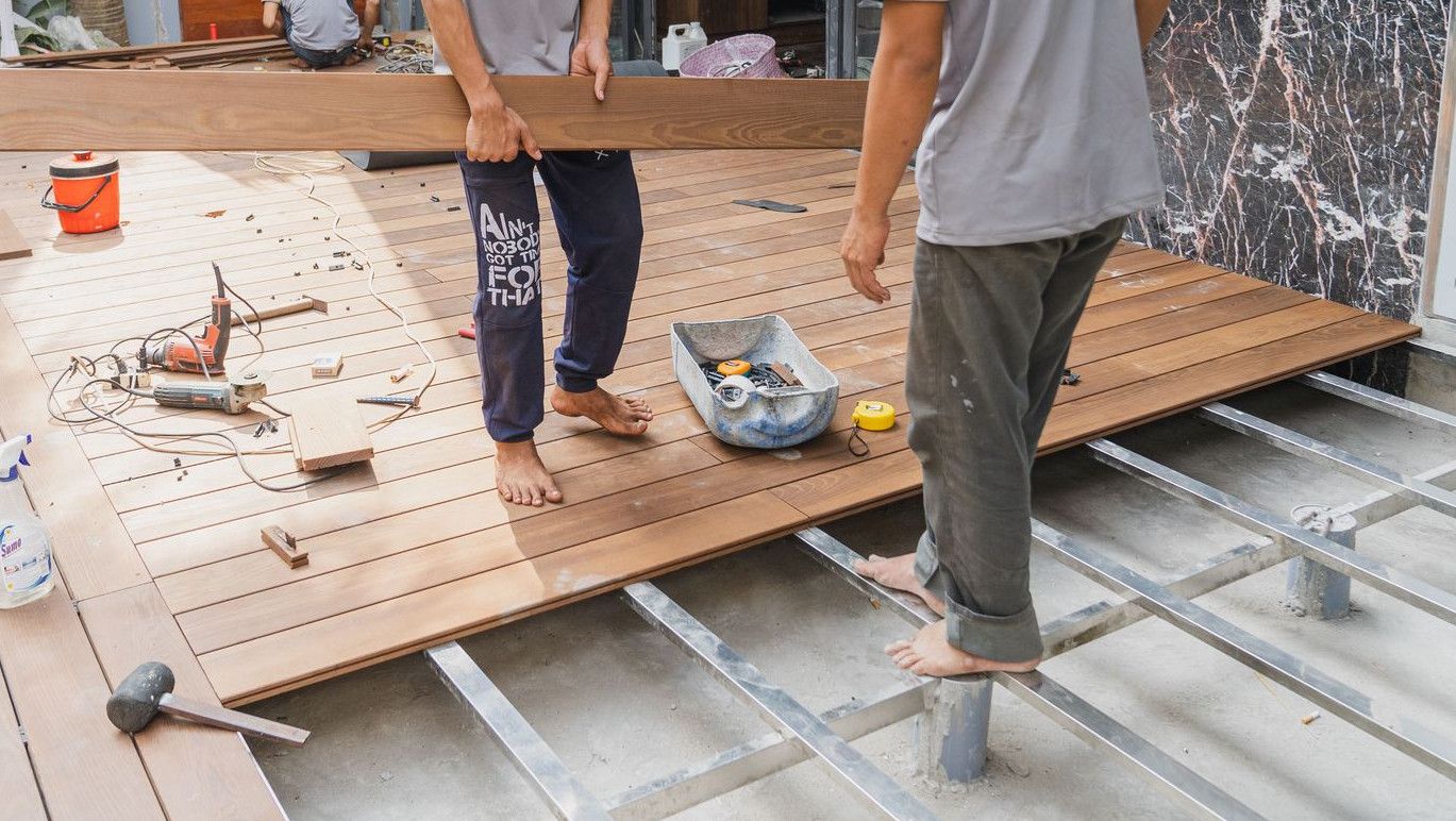 Carpenters working on a wooden floor installation in Hồ Chí Minh, Việt Nam.